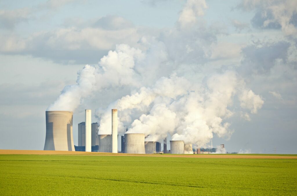 Green Fields In Front Of Industry Skyline